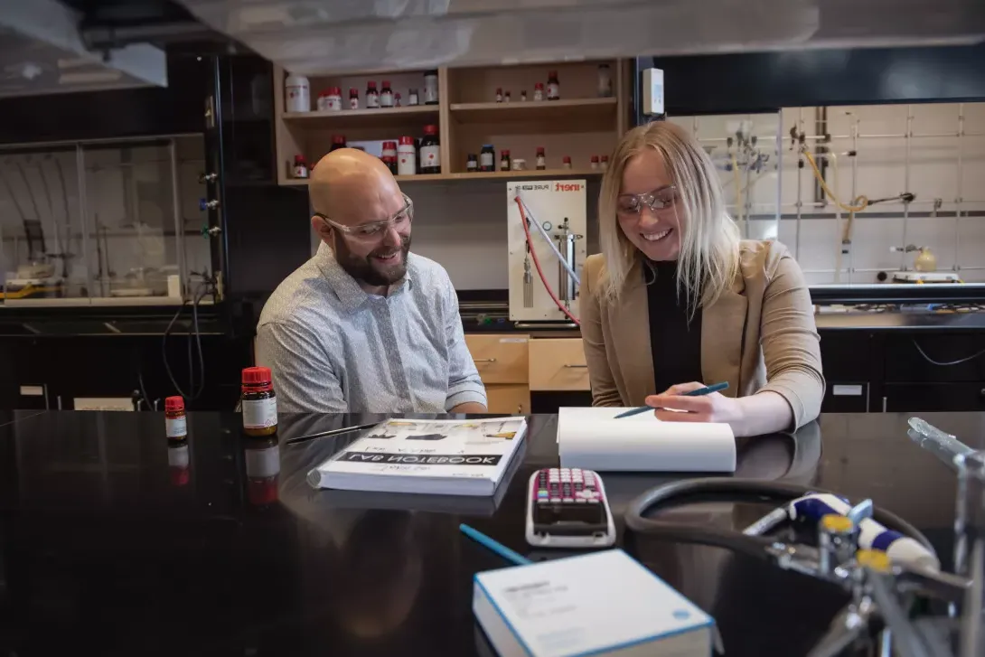 Student going over chemistry lab work with instructor